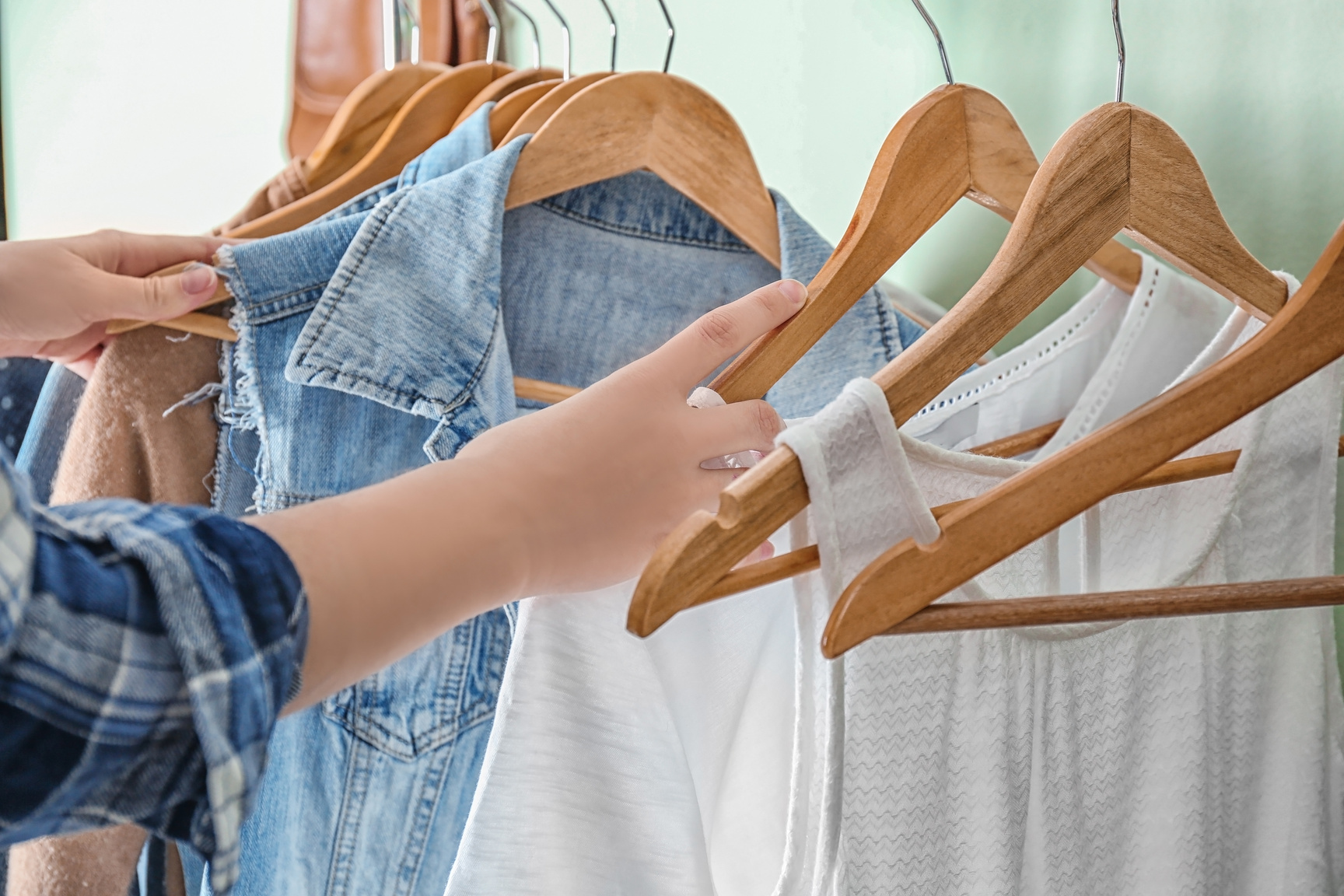 Person Choosing Clothes on Rack